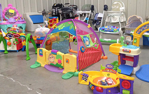 Assortment of colorful childrens tents, strollers, high chairs and toys on display